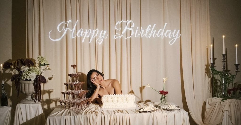Elegant birthday celebration display with champagne tower, cake and Happy Birthday sign